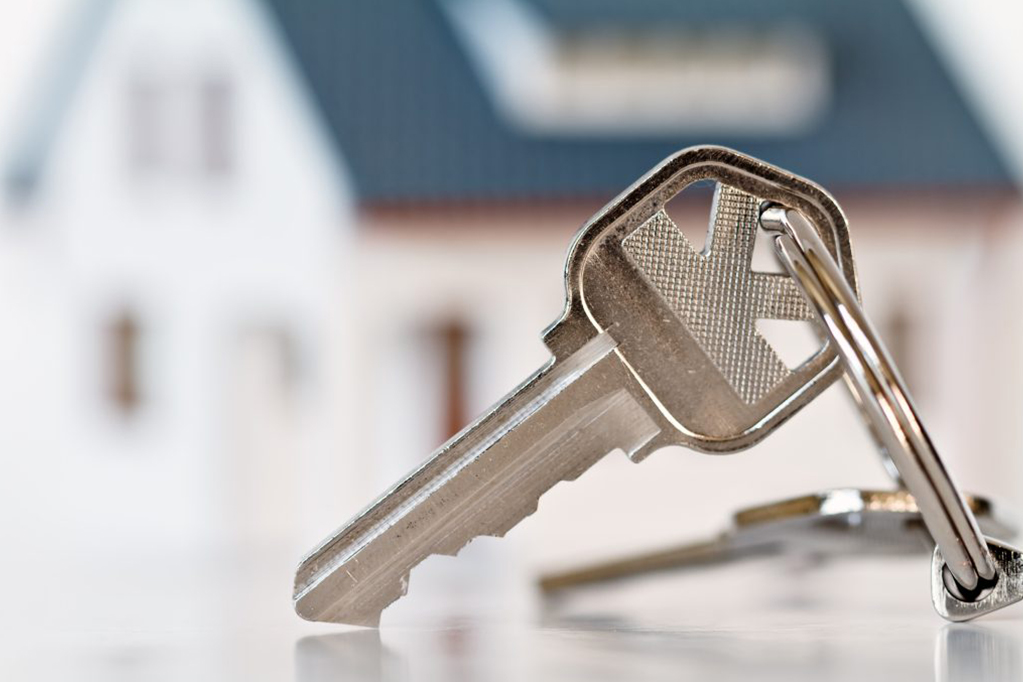 Silver Key In Front Of White Model Home